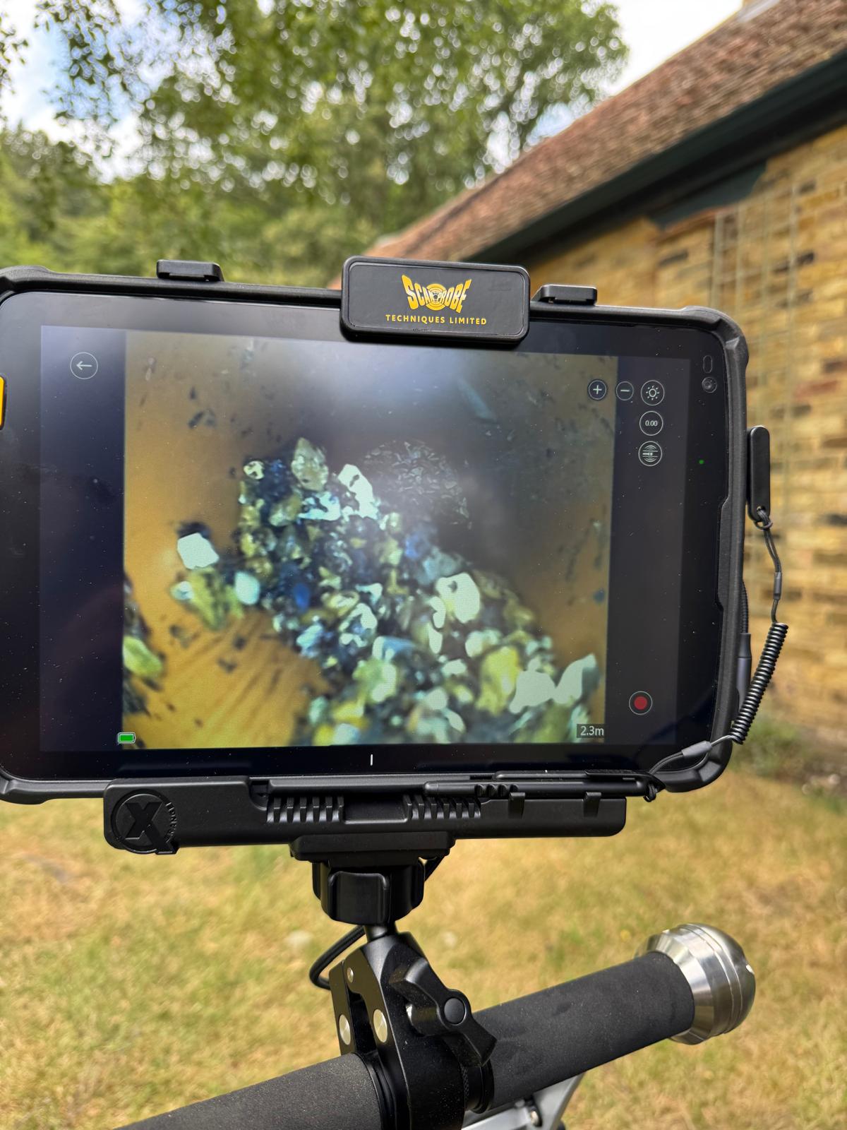 CCTV monitor showing debris inside drain pipe